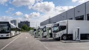 Flotas eléctricas de transporte y logística conectadas a puntos de carga en un centro operativo.